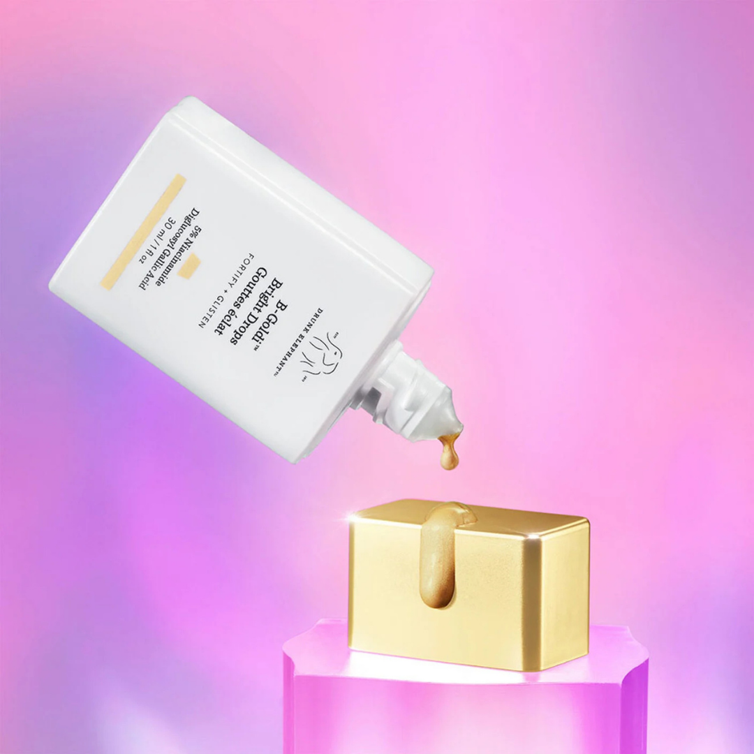 Skincare product being applied to a gold container on a gradient background