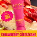 NYX Professional Makeup lip balm with strawberry cheesecake flavor on a background of strawberries and cheesecake.